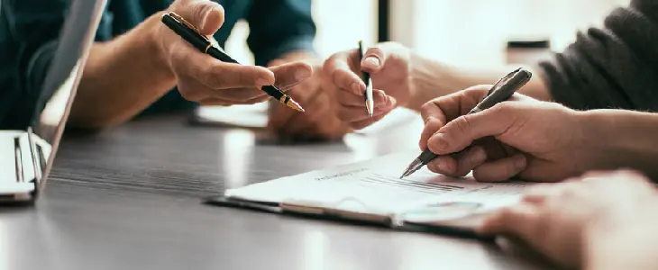 Lawyer overseeing the creation of a contract while directing his clients